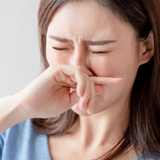 Woman touching nose in discomfort showing nasal obstruction and breathing difficulty symptoms