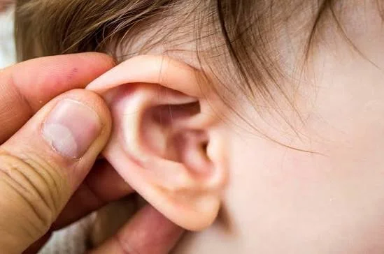 Close up of parent examining child ear for signs of earache and otitis media at Center of ENT Lahore