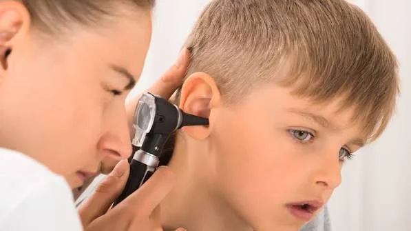 Pediatric ENT specialist using an otoscope to examine young boy ear canal at Center of ENT Lahore