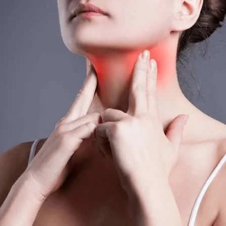 Woman touching inflamed neck with glowing red throat pain area evaluated at Center of ENT Lahore